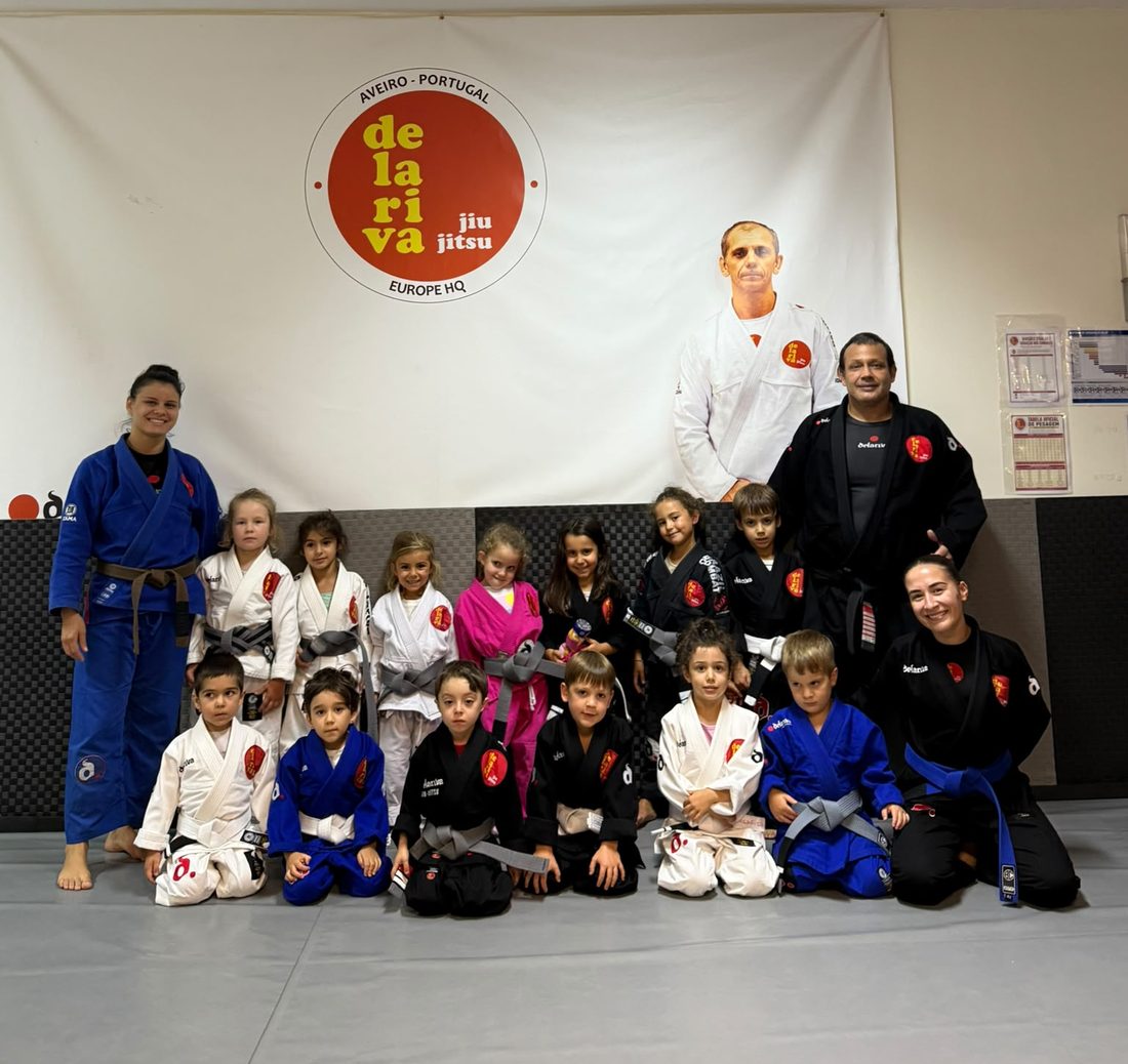 Turma Kids da Escola Delariva Aveiro com os professores, em frente ao logótipo da escola